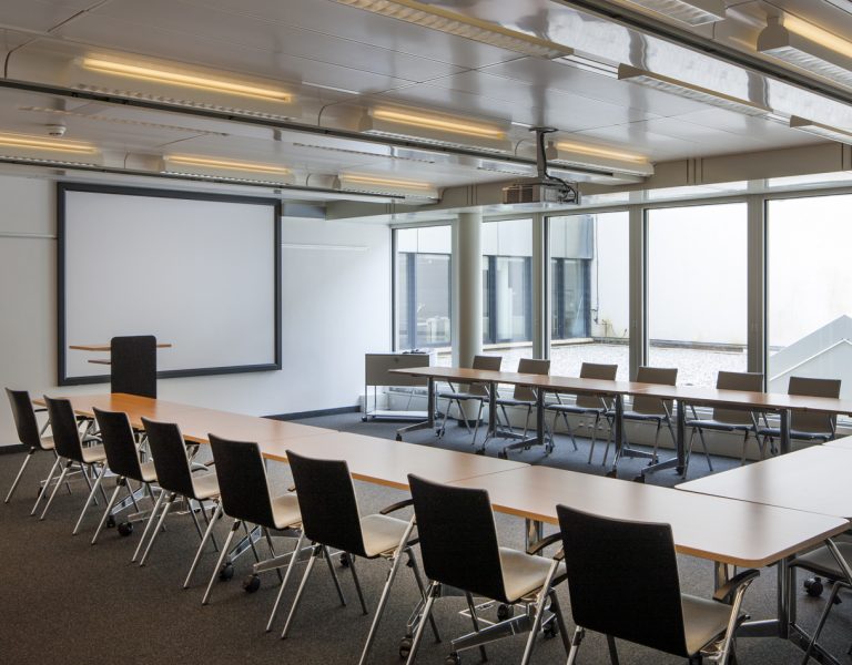 Salle de conférence lumineuse avec tables en U – espace professionnel pour séminaires et réunions d’entreprise