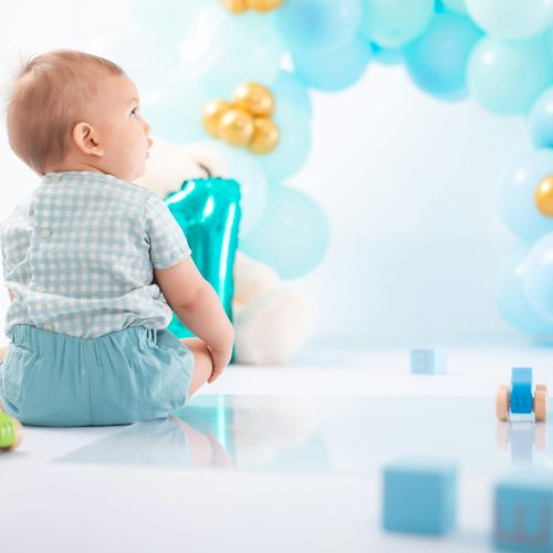 Enfant entouré de ballons bleus – organisation d’anniversaires et événements familiaux à Genève