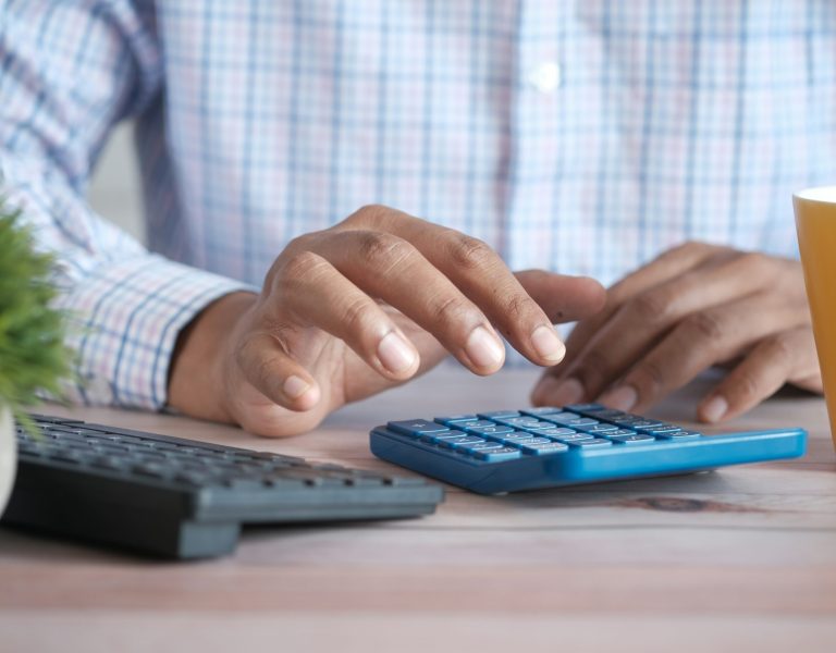 Calculs financiers sur bureau avec calculatrice et clavier – gestion budgétaire pour événements sur mesure à Genève